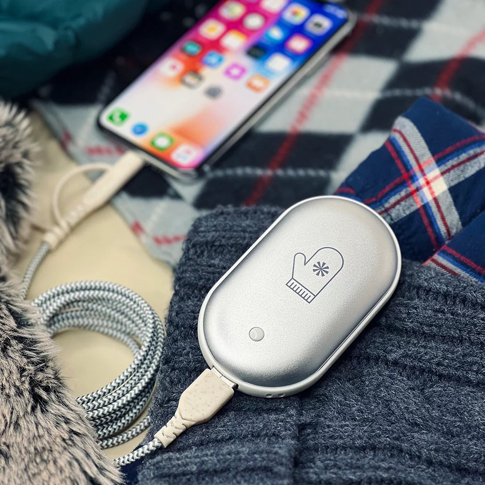 Handheld device with cable on a checkered blanket next to a phone