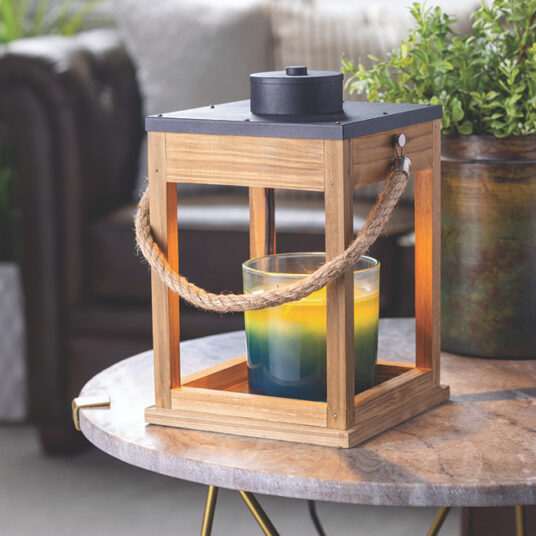 Wooden lantern with a candle on a table outdoors