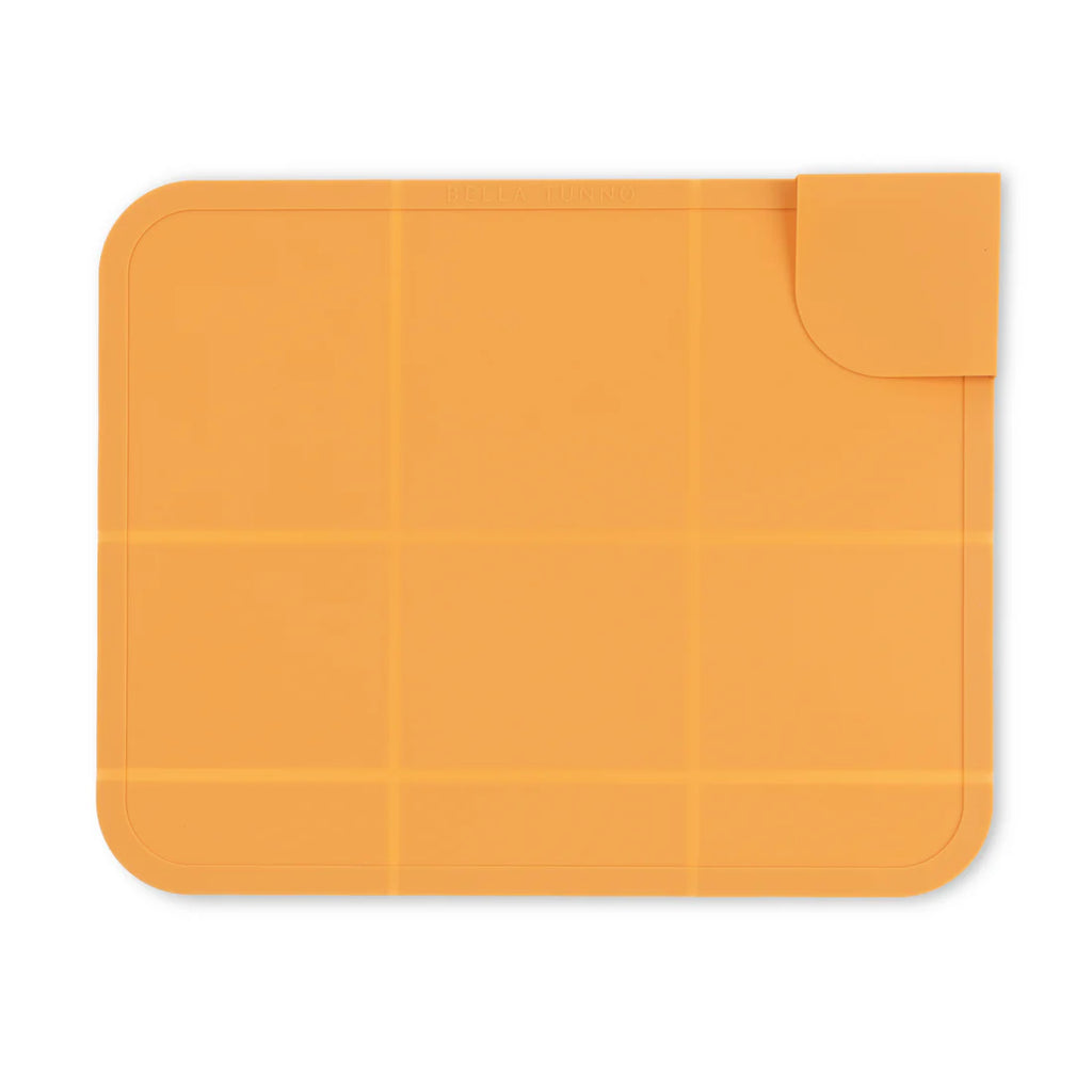 Orange silicone mat with a textured surface on a white background