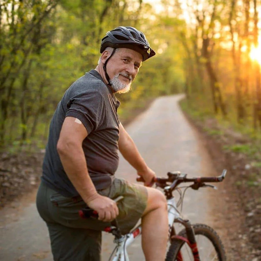 man riding a bike down wooded trail with a patch on