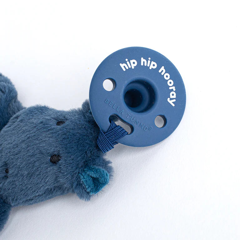 flat stuffed animal attached to a pacifier on a white background