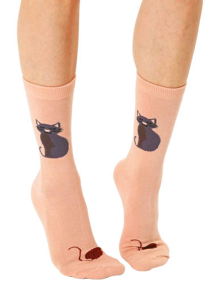 Pink socks with cat and mouse design worn by a person on a white background