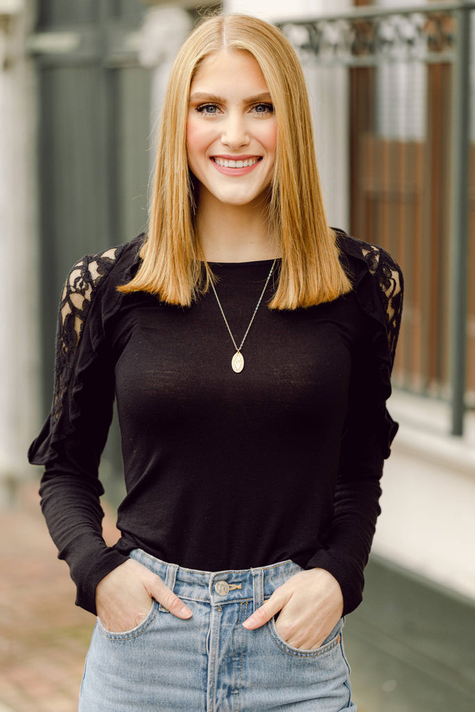 person wearing a necklace in front of a gate