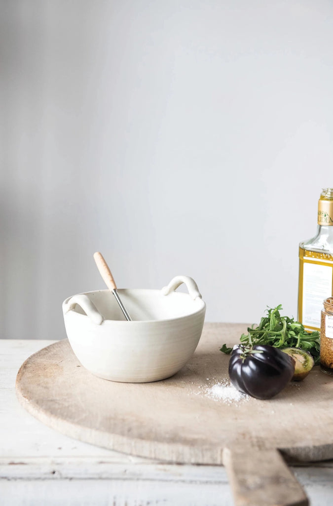 stoneware batter bowl and metal whisk on a white background