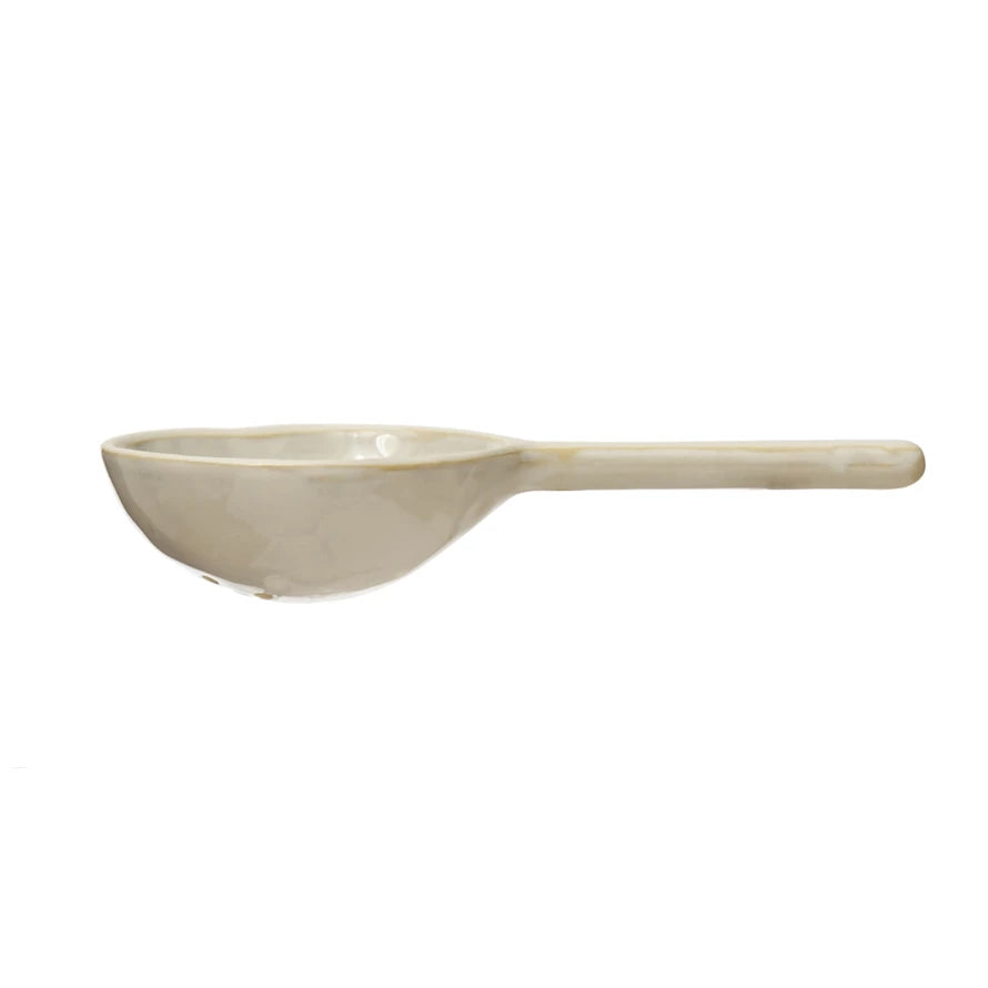 stoneware strainer spoon on a white background