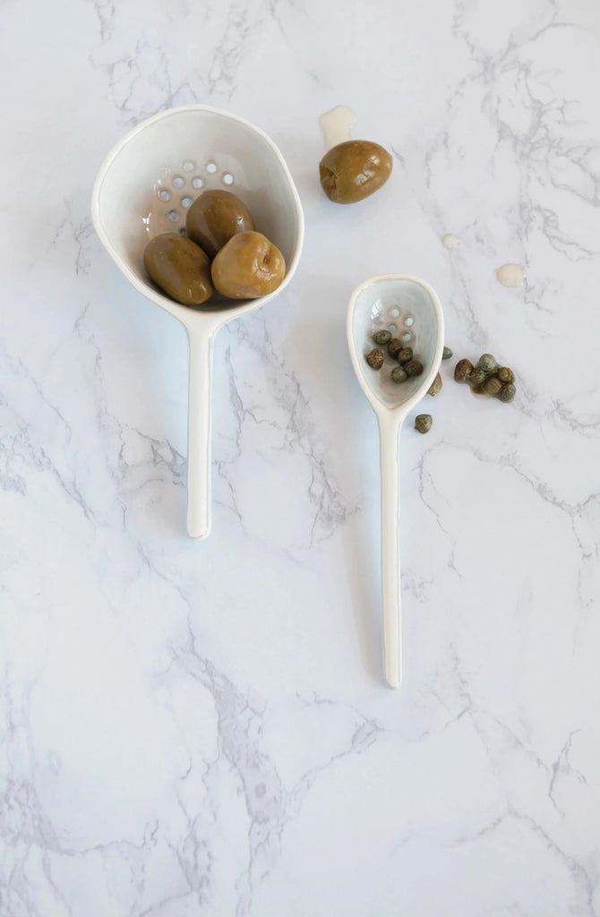 stoneware strainer spoon on a white background