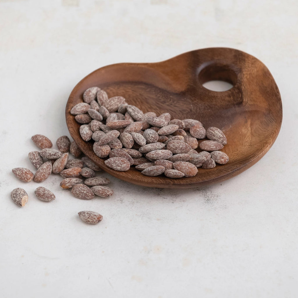 wood tray full of almonds on a white background