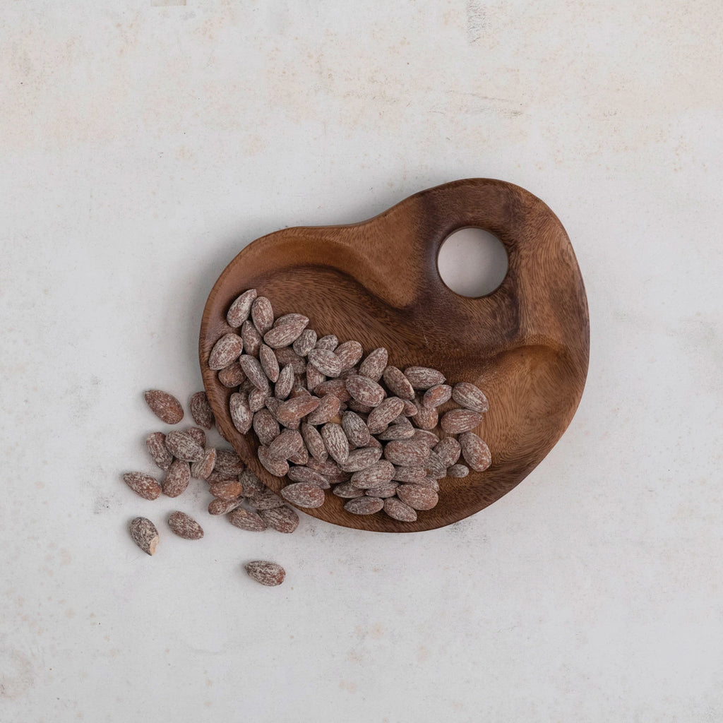 wood tray full of almonds on a white background