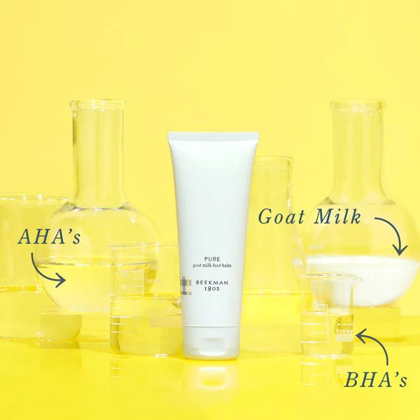 bottle of beekman 1802's pure goat milk foot balm with beakers, flasks, and conical flasks holding the product's that are in the foot balm: goat milk, BHA's, and AHA's on a yellow background
