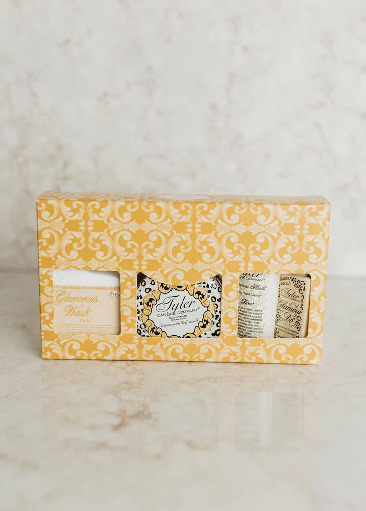 Tyler candle company gift set with laundry detergent, candle, hand lotion, and poop odor cover on a marble background