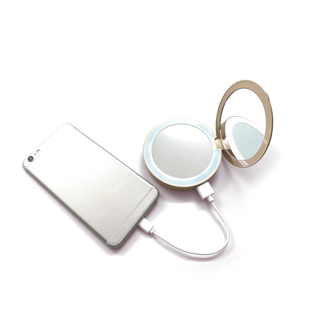Foldable mirror with light attached to a smartphone on a white background