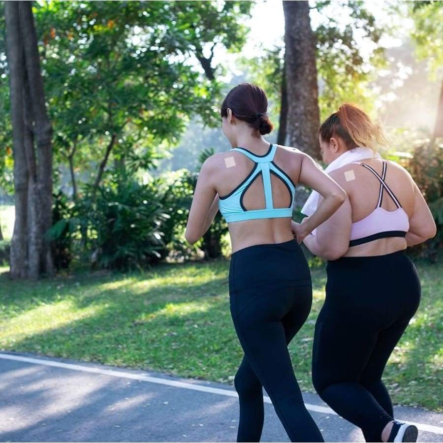 running women on a city park path wearing patches