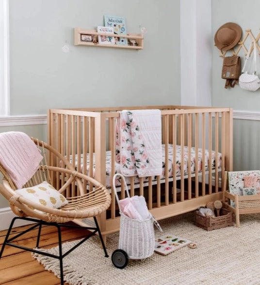 baby nursey with crib chair and rug with green walls