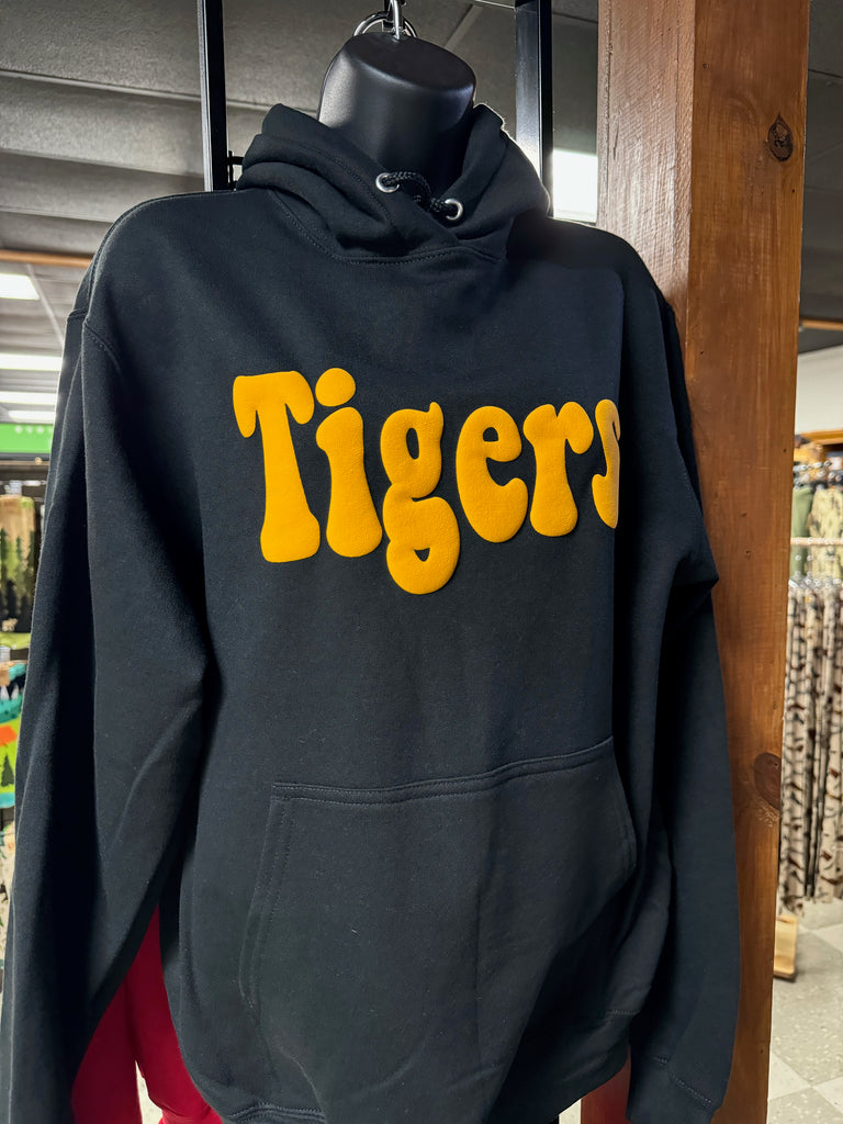Black hoodie with 'Tigers' printed in yellow on a wooden surface.