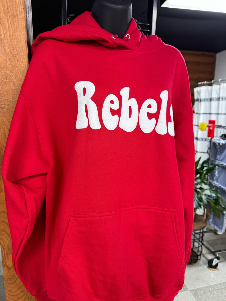Red hoodie with 'Rebell' text on a wooden surface