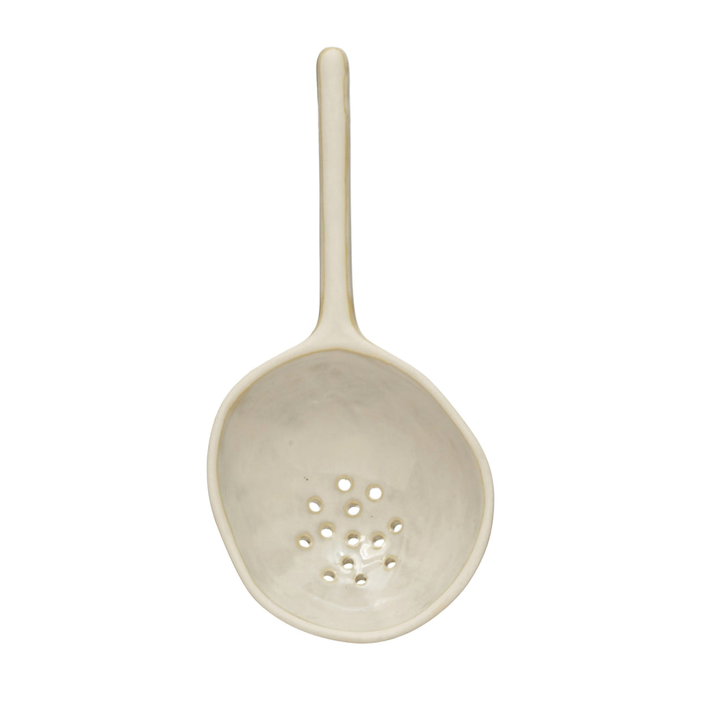 large stoneware strainer spoon on a white background