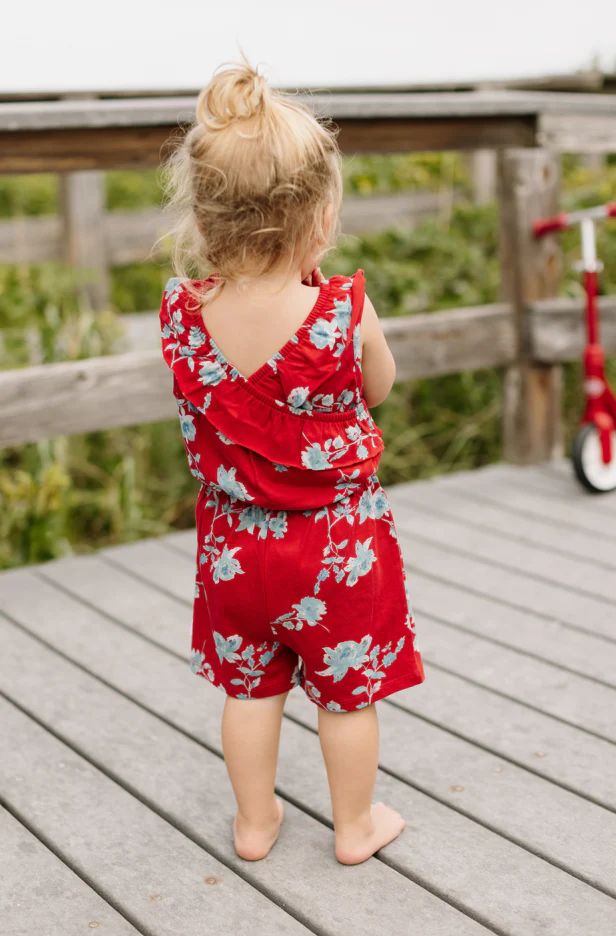 burts bee july floral romper on a pier