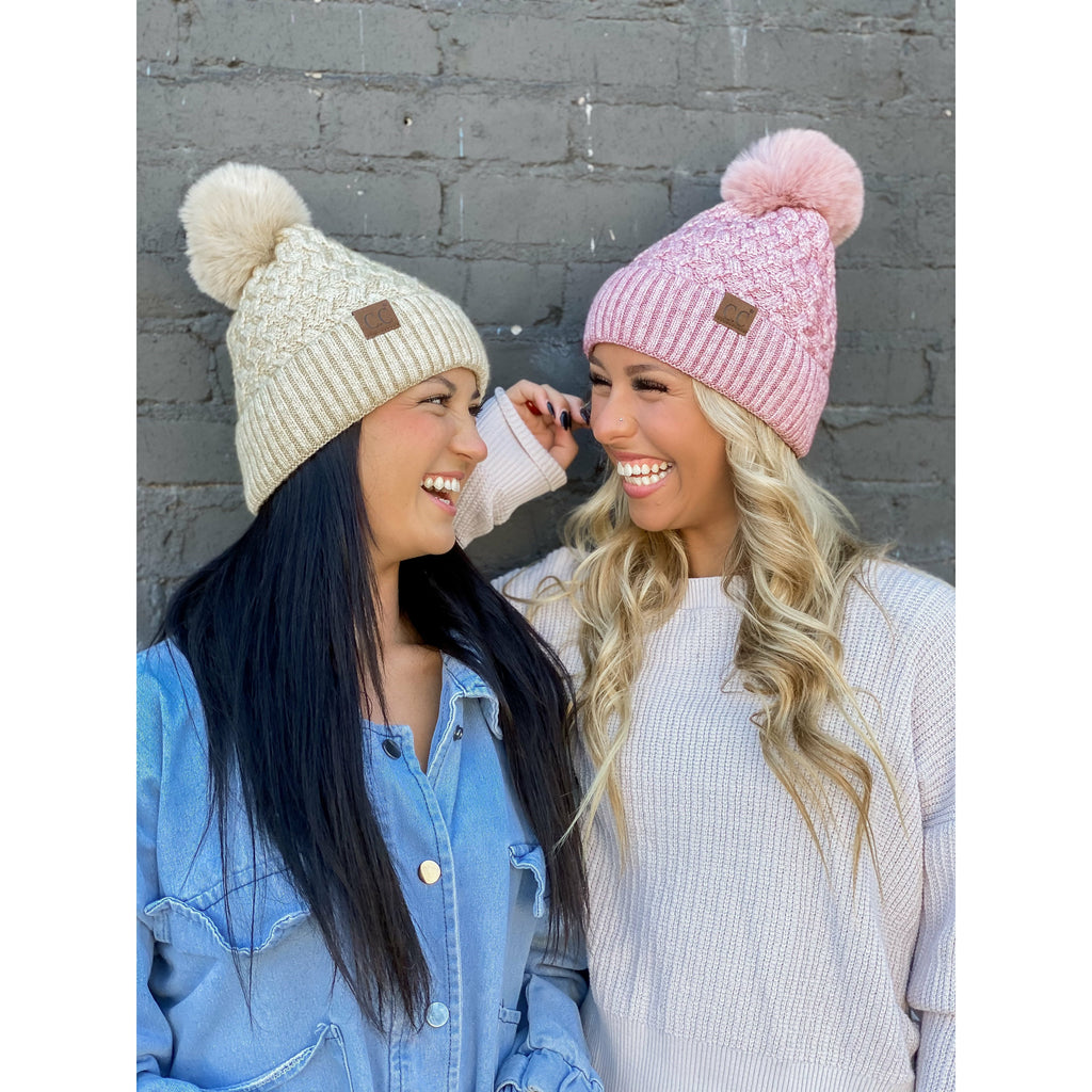 girls wearing woven cable knit matching pom cc beanie in front of a gray wall