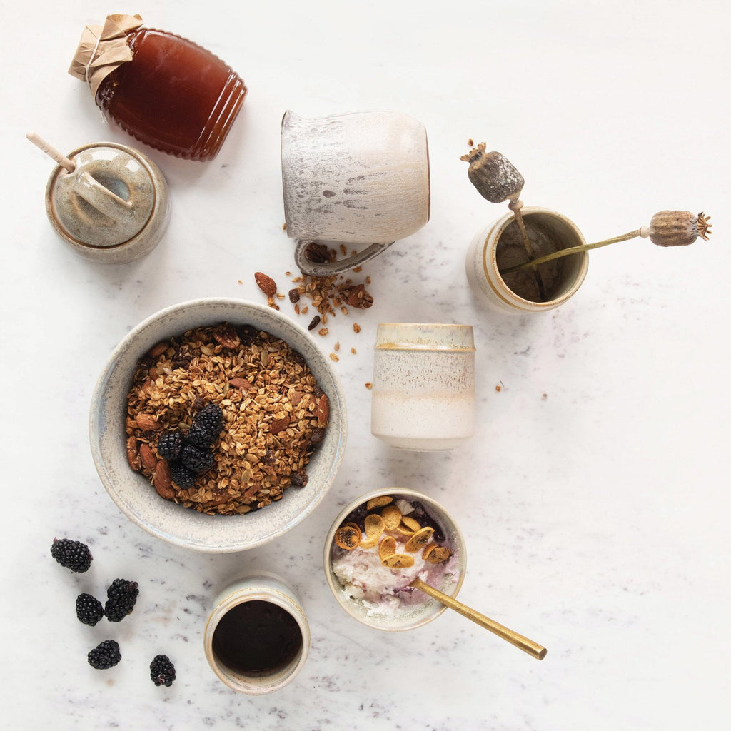 stonewear honey jar with honey dipper on a white background