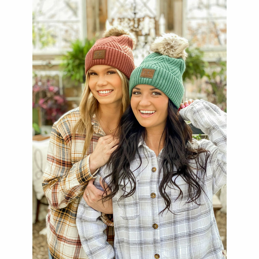 girls wearing large patch heathered pom cc beanies in a house