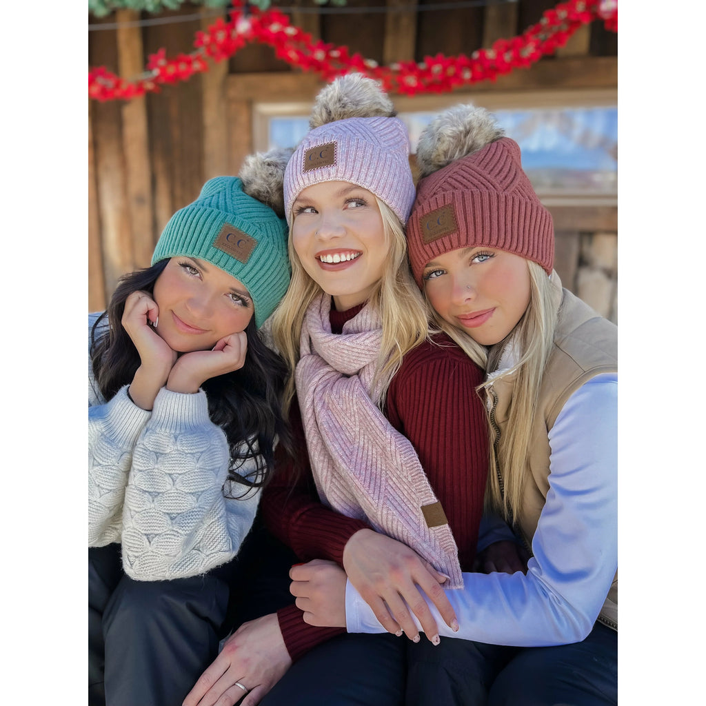 girls wearing large patch heathered pom cc beanies in front of a house