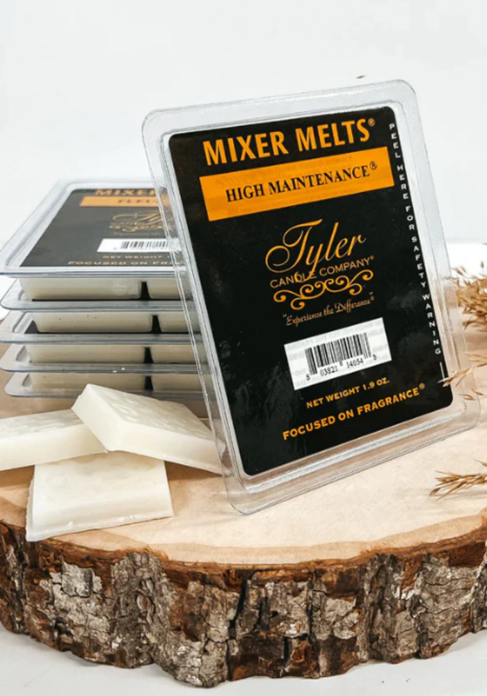 high maintenance wax melts on a wood log on a white background