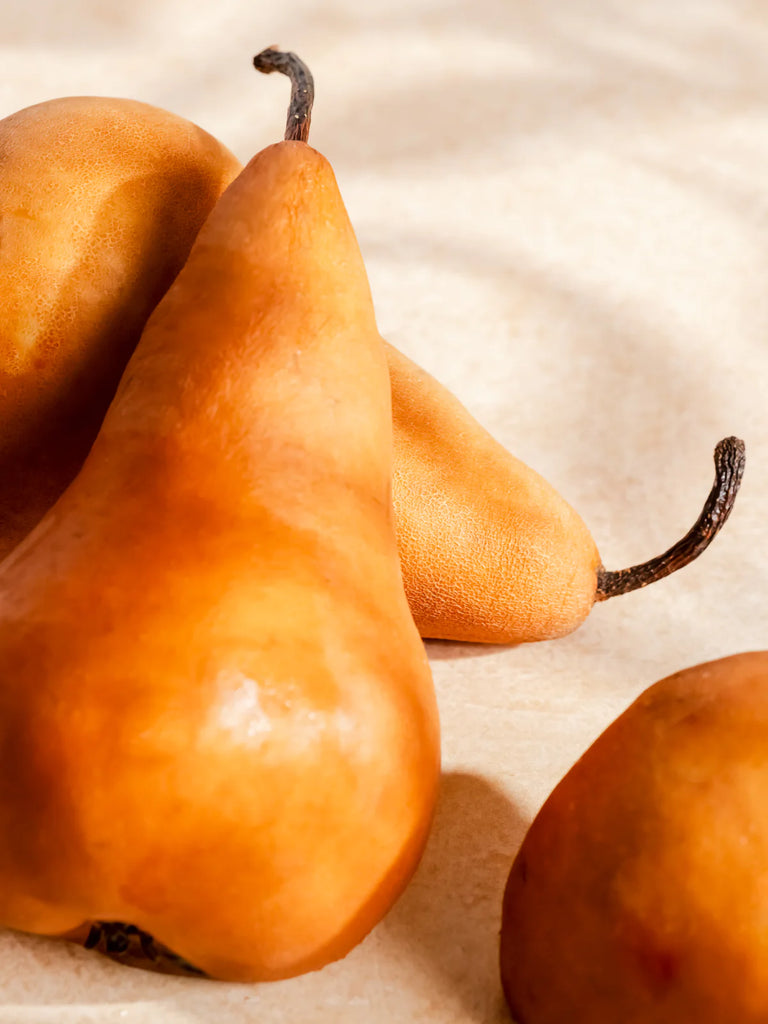 close up pears on a tan background