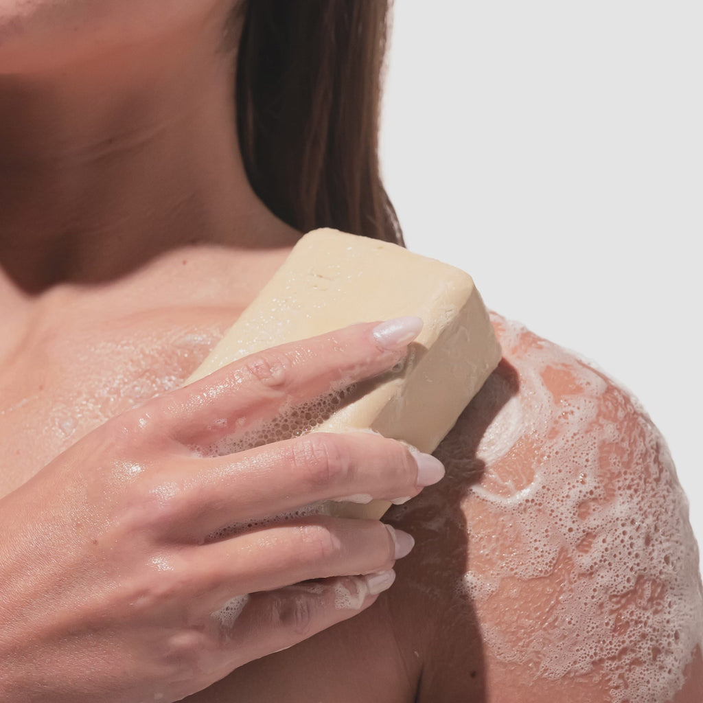 beekman golden bar soap being rubbed into skin
